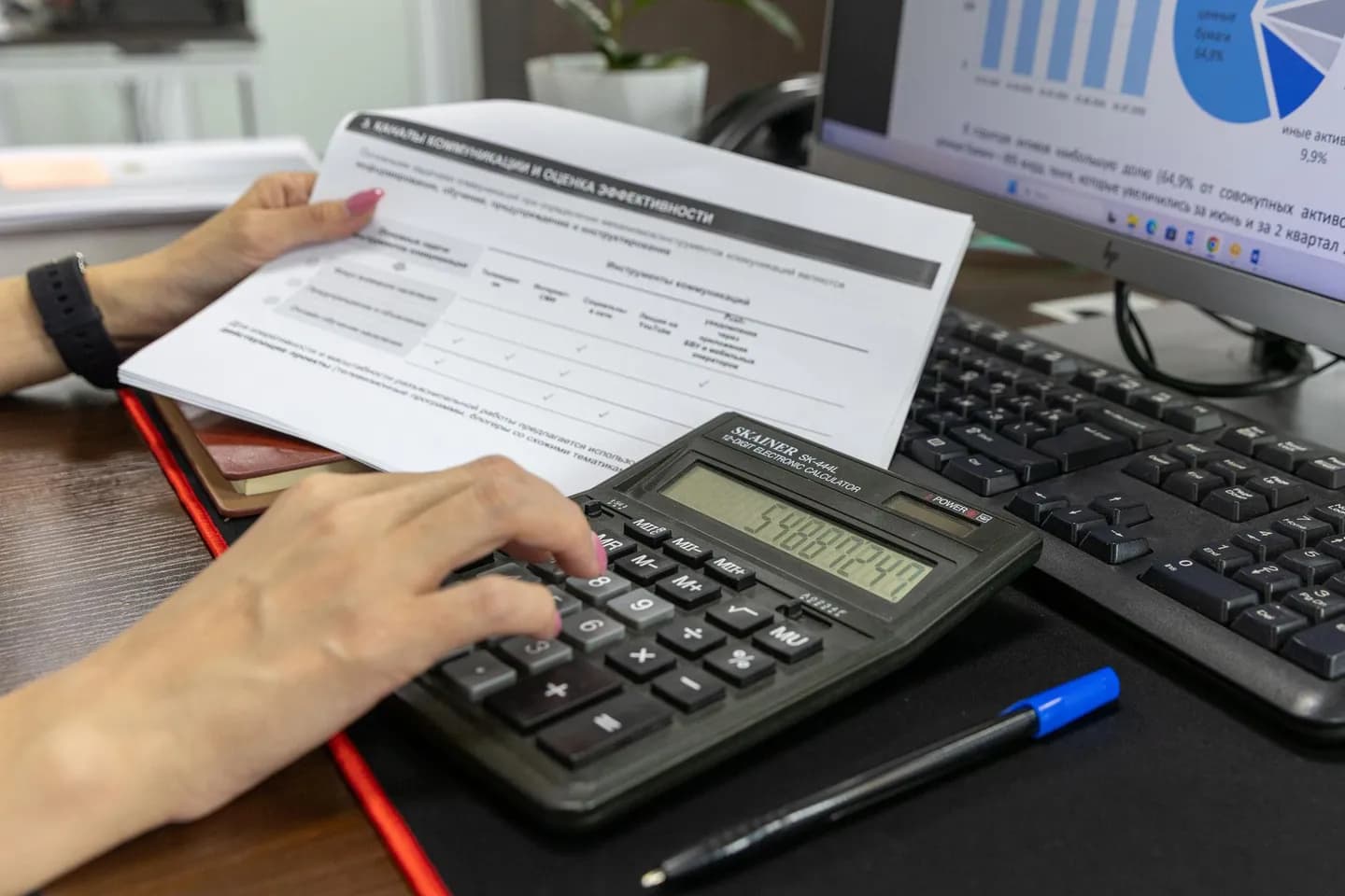 image to excel: a person checks a financial document with a calculator