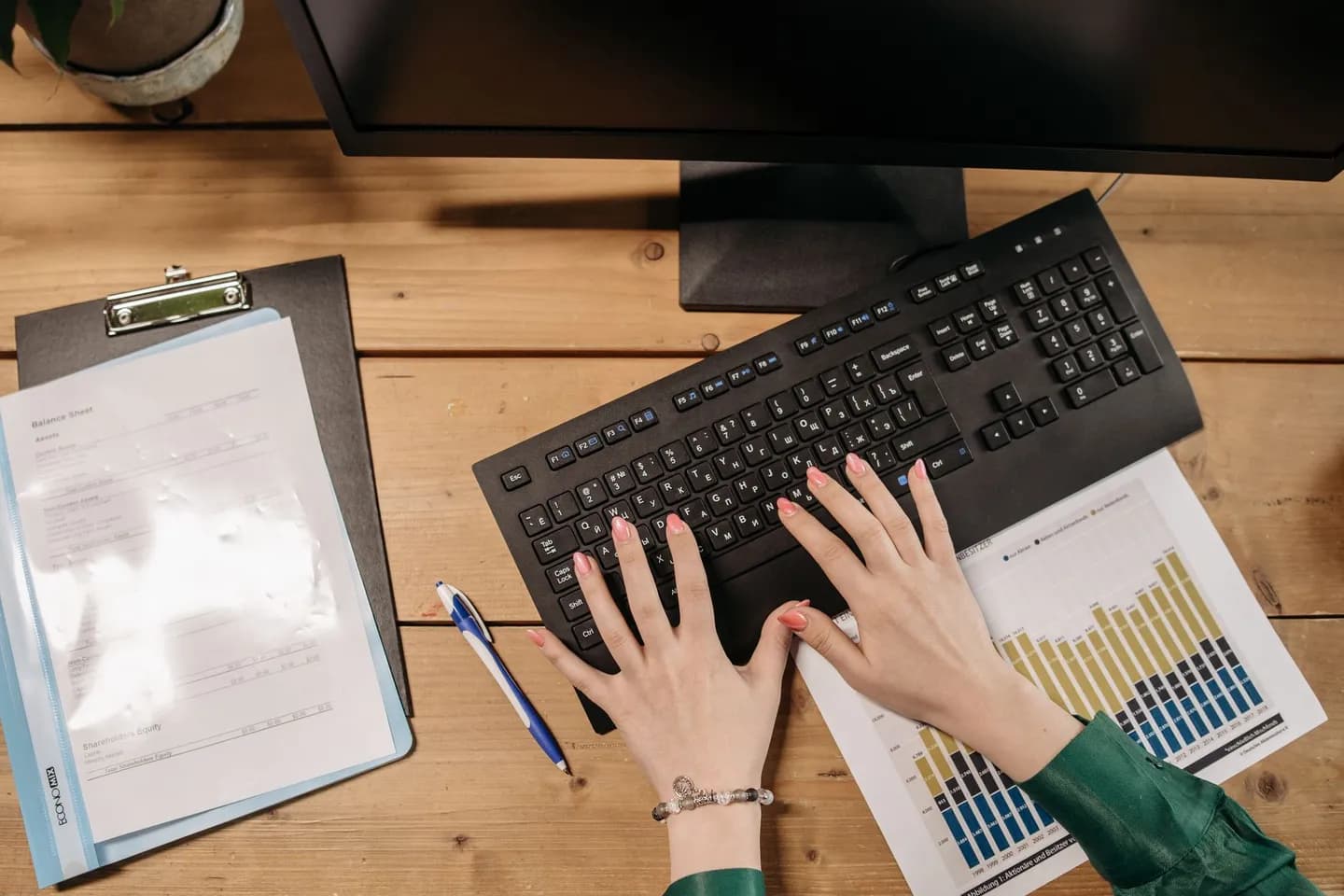 remove secrets from text: a person typing beside printed charts