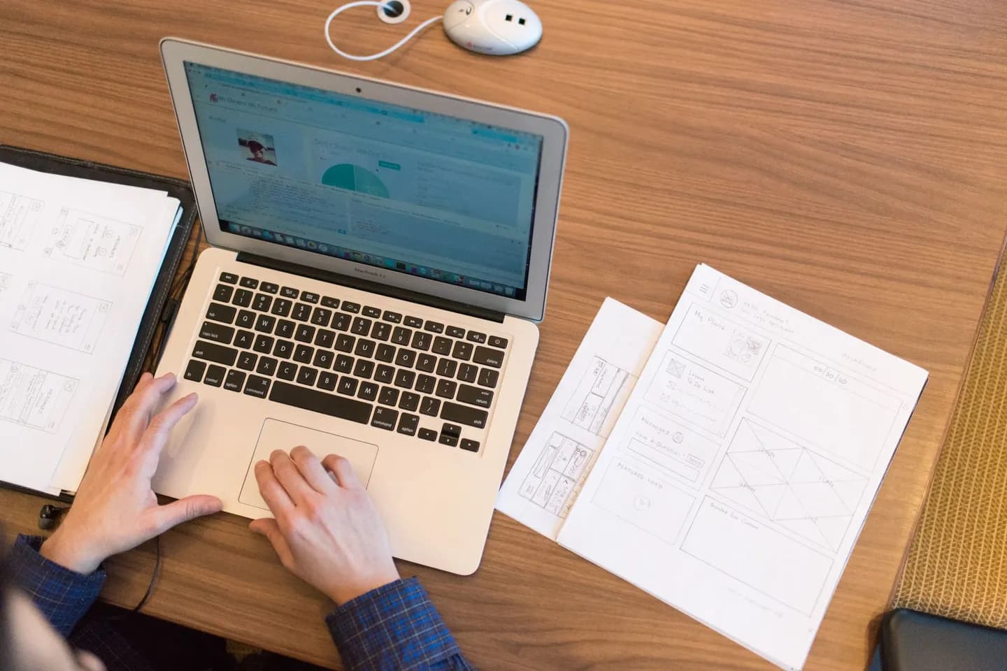 how to anonymize text: hands on a laptop beside paper documents