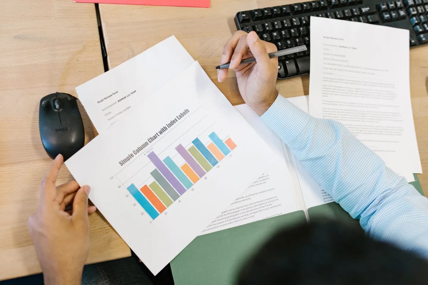 copy text from pdf: a person holding a printed chart beside desk documents